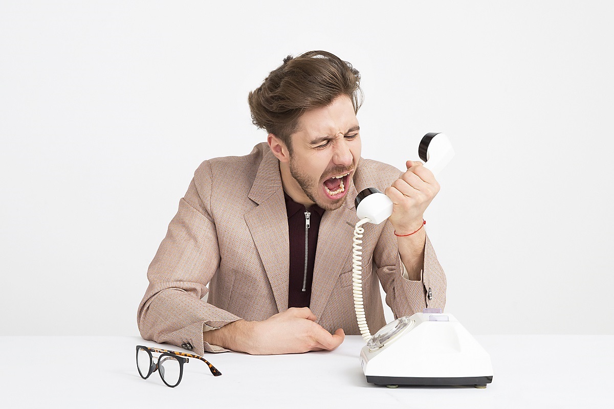 Homem gritando ao telefone e oferecendo um mau atendimento