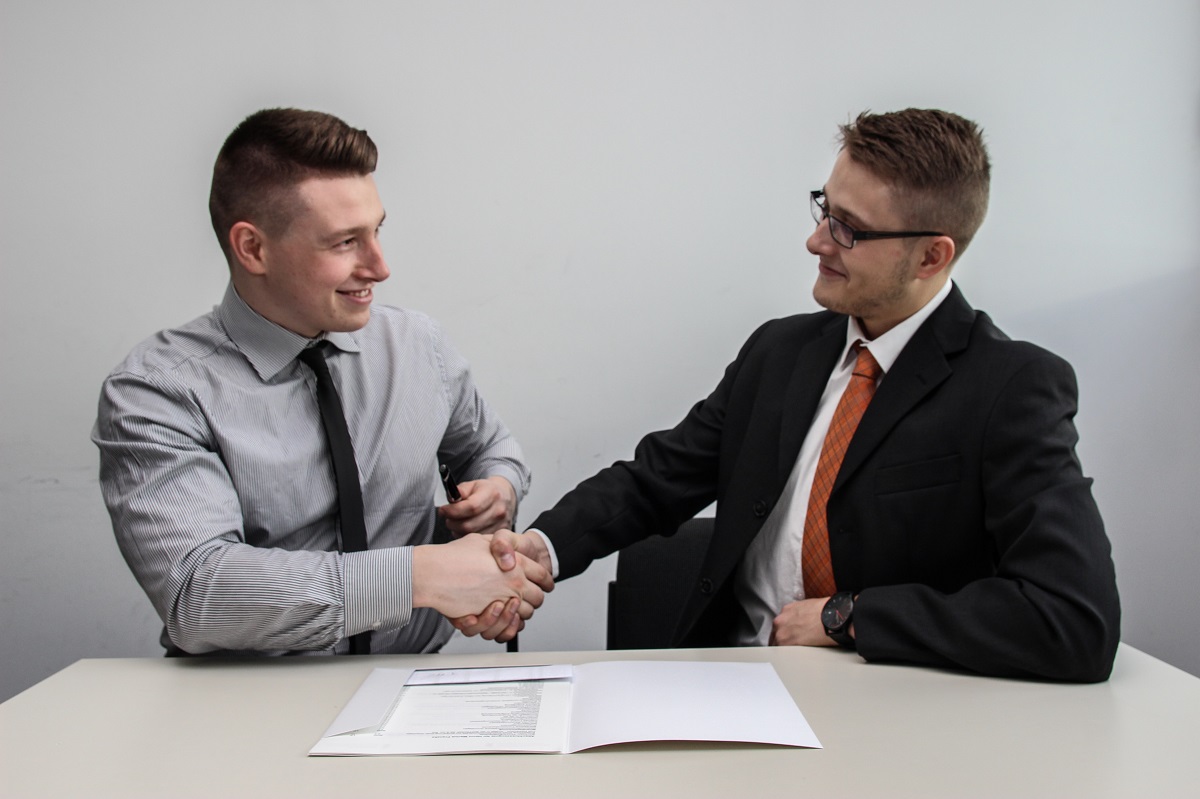 Dois homens se cumprimentando e fazendo fidelização de clientes