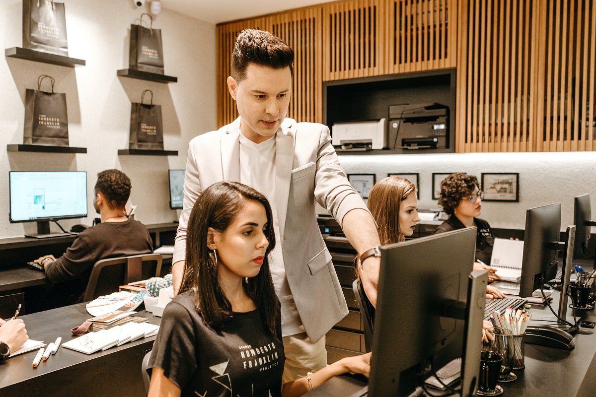 Homem ensinando mulher da equipe no escritório