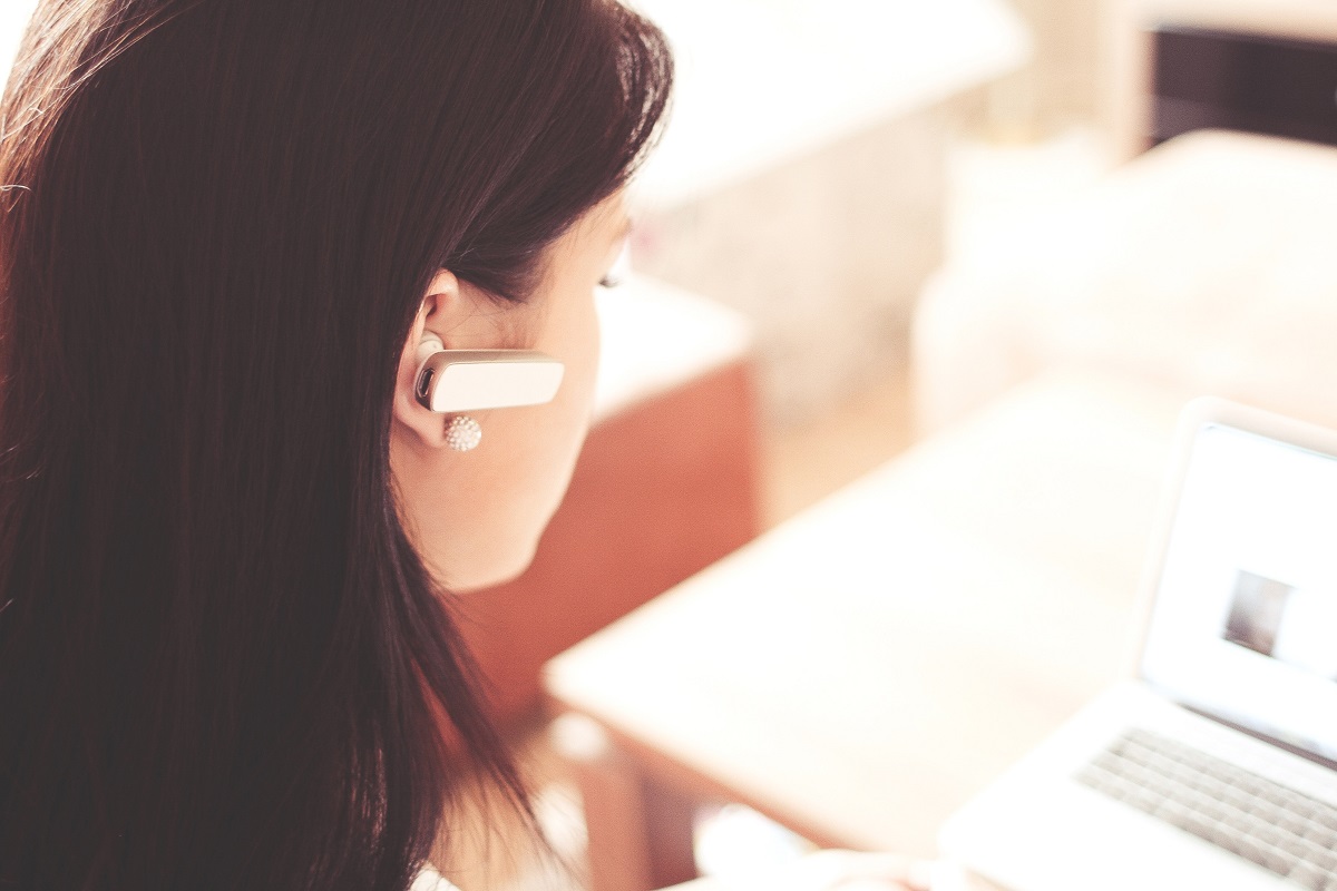 Mulher com fone headset fazendo atendimento ao cliente