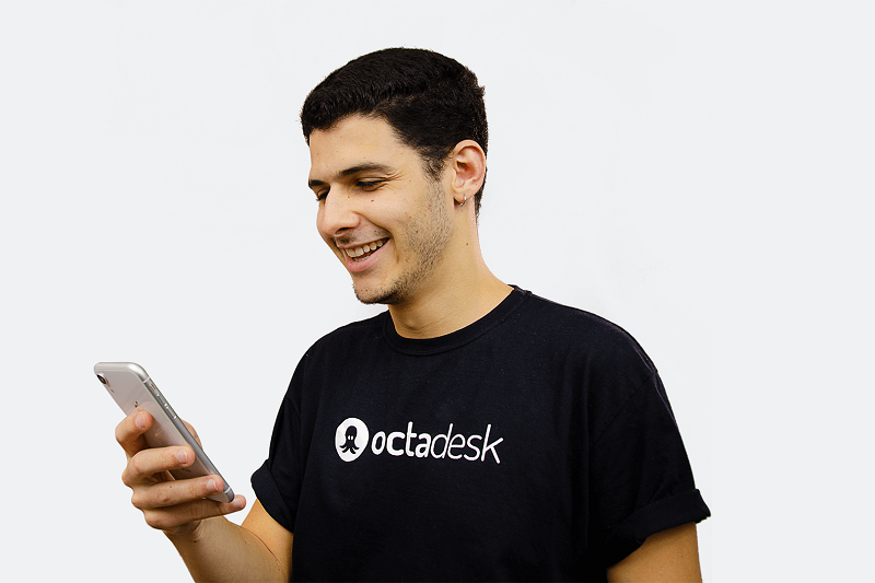 Homem colaborador da Octadesk segurando smartphone